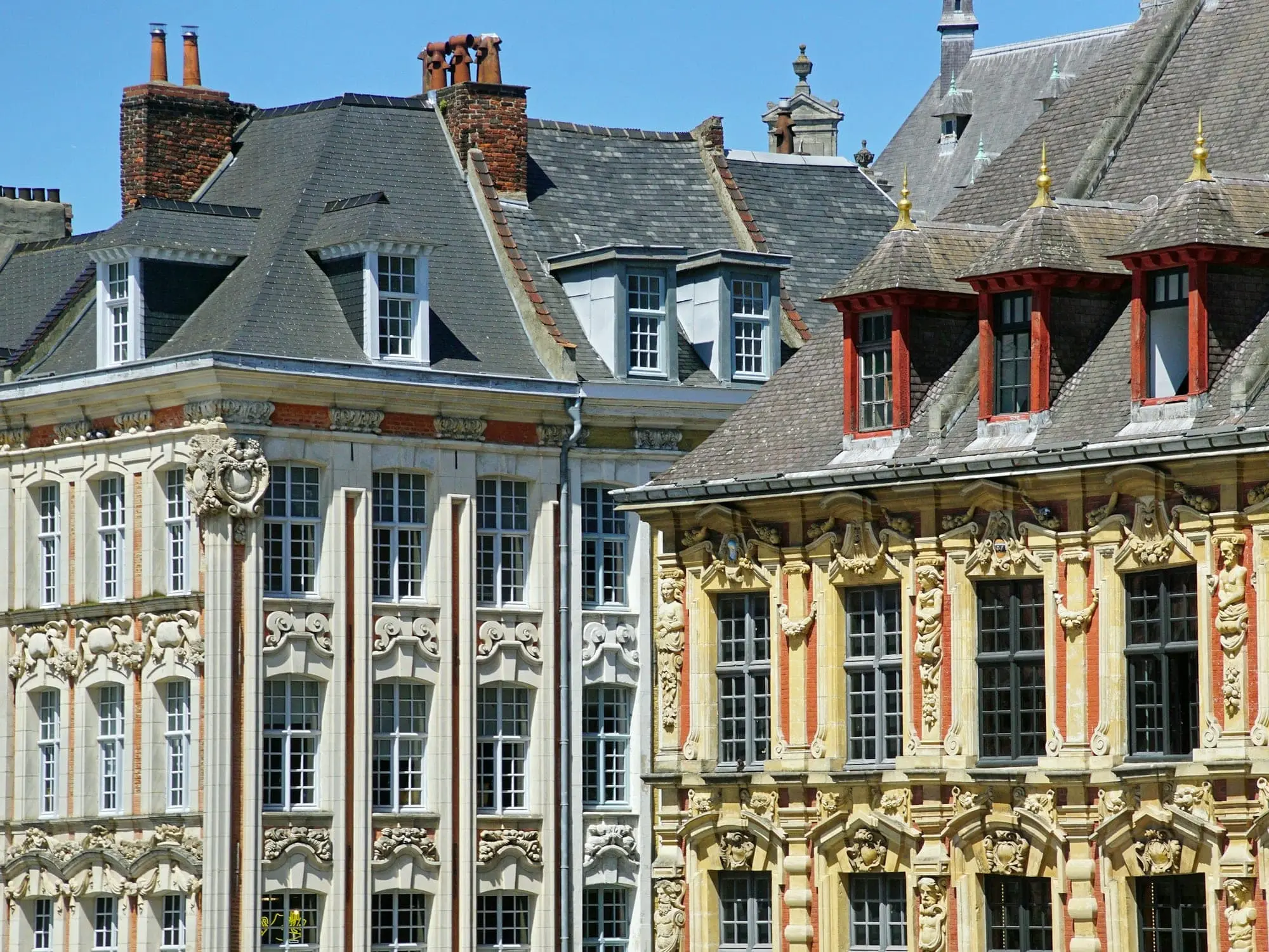 Les façades flamandes de la Grand-Place de Lille, pierre sculptée, brique rouge et lucarnes, sous un ciel bleu