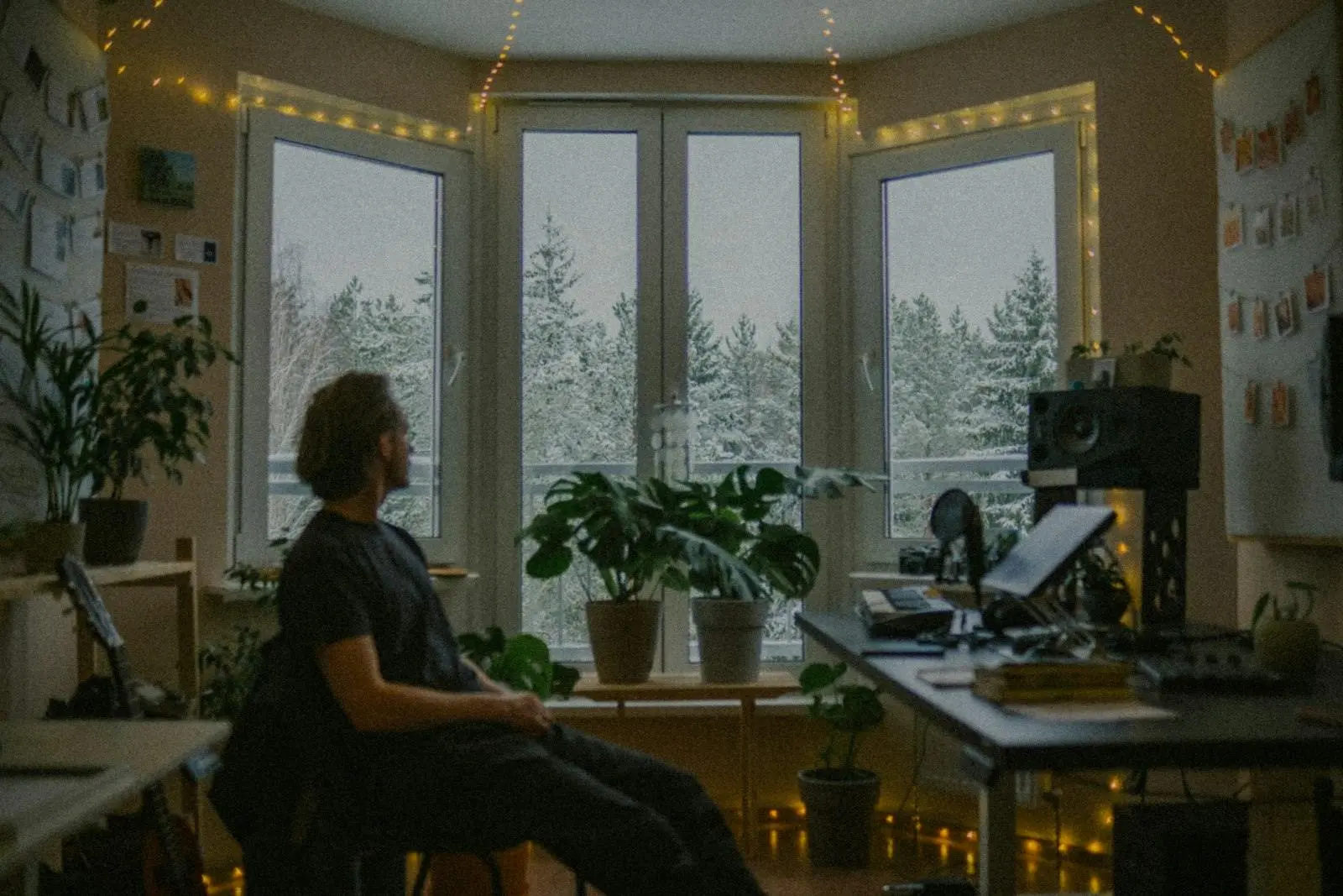 Un homme assis dans son bureau à domicile regarde par la fenêtre